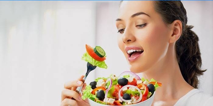 La ragazza mangia insalata di verdure in base alla dieta per dimagrire gambe e fianchi