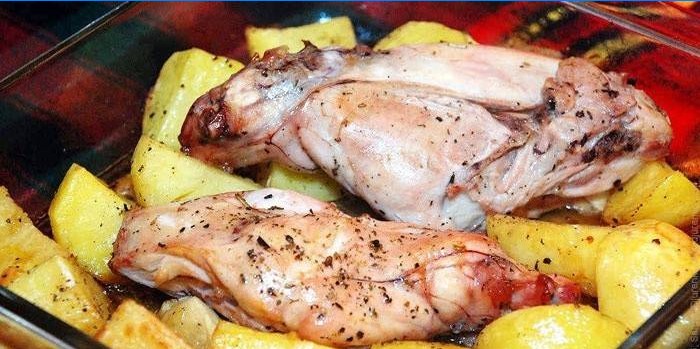 Carne di coniglio su un cuscino di patate prima della cottura