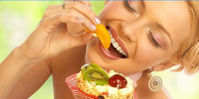 La ragazza mangia frutta e torta