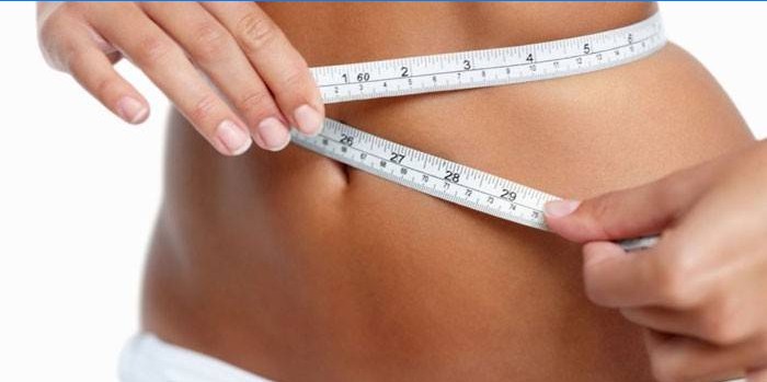 La ragazza misura la vita con un centimetro