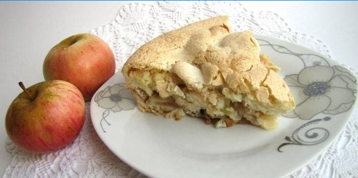 Una fetta di torta di mele su un piatto e mele