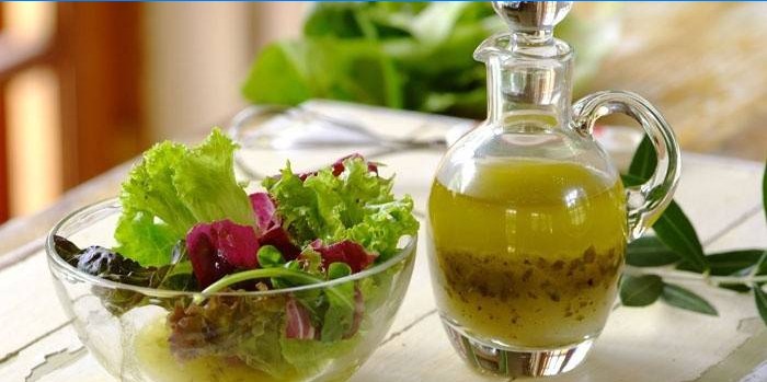 Foglie di insalata in una ciotola e condimento pronto per condimento
