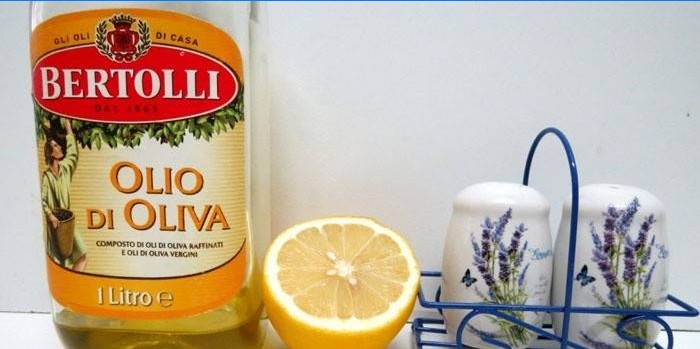 Olio d'oliva in una bottiglia, limone e spezie