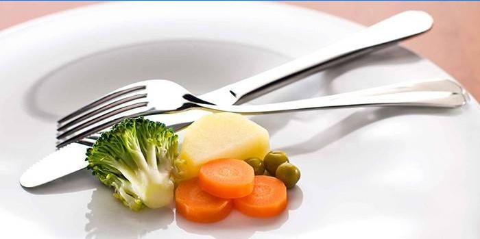 Piccola porzione di verdure su un piatto e forchetta