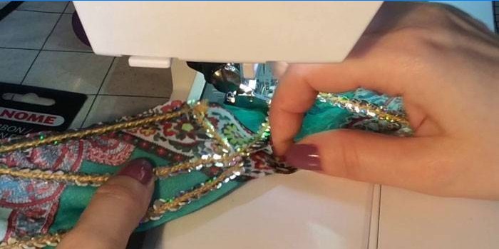 La donna cuce paillettes su un filo al tessuto