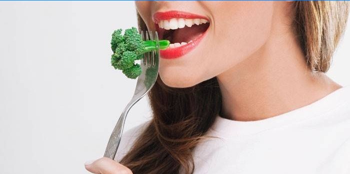 La ragazza mangia broccoli