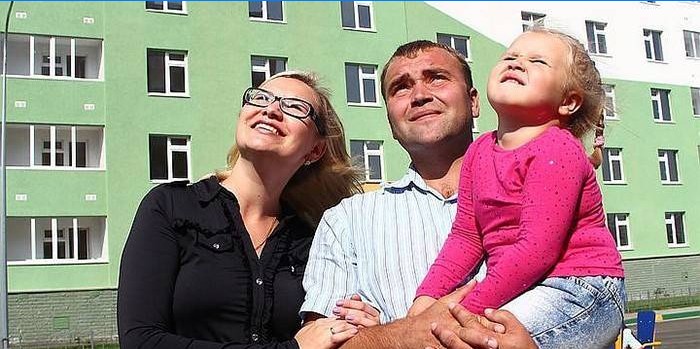 Giovane famiglia sullo sfondo di un nuovo edificio