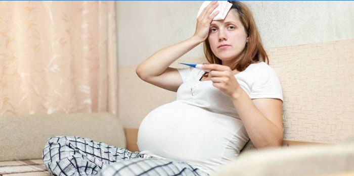 Ragazza incinta con un termometro