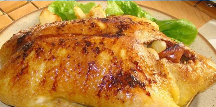 Uccello intero arrosto con mele su un piatto