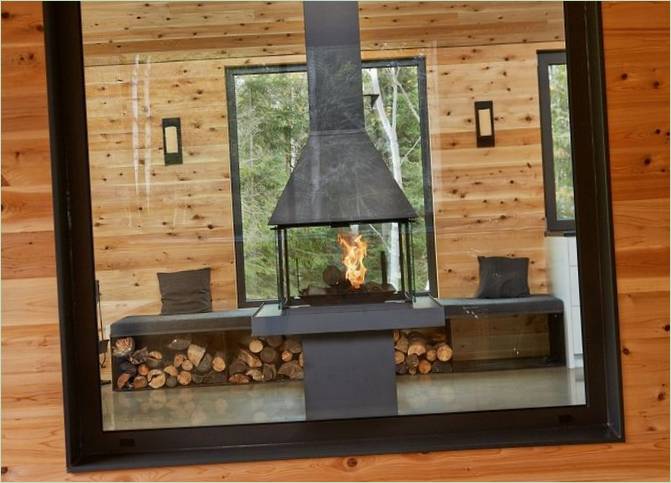 Design di una casa in legno in Quebec: un camino nell'interno del soggiorno