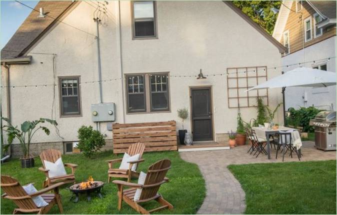 Patio trasformato con lettini, focolare e cucina estiva Cortile trasformato con sedie a sdraio, focolare e cucina estiva