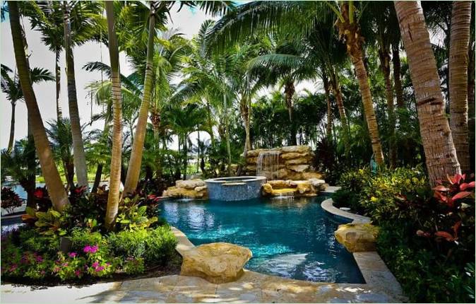 Una piscina tropicale su un letto di vegetazione Una piscina tropicale su un prato verde