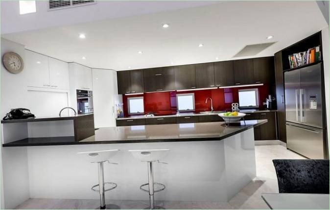 Cucina con bar per la colazione e sedie in una casa a Perth