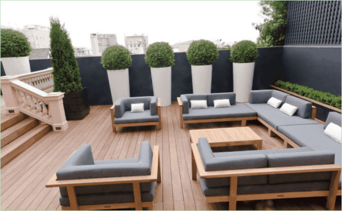 La terrazza di una casa di campagna - divani grigi e piante verdi La terrazza del giardino della vostra casa di campagna - divani grigi e piante verdi