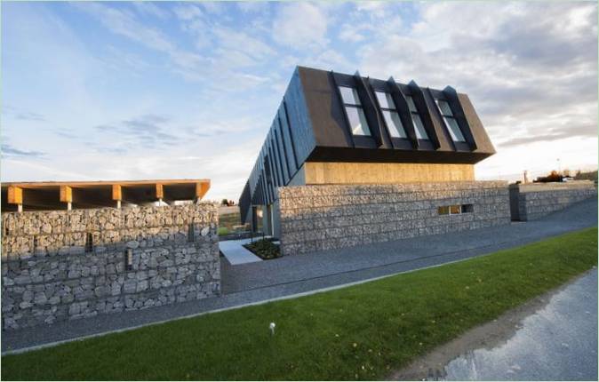 Casa in mattoni e legno di Snøhetta: l'alta recinzione in pietra