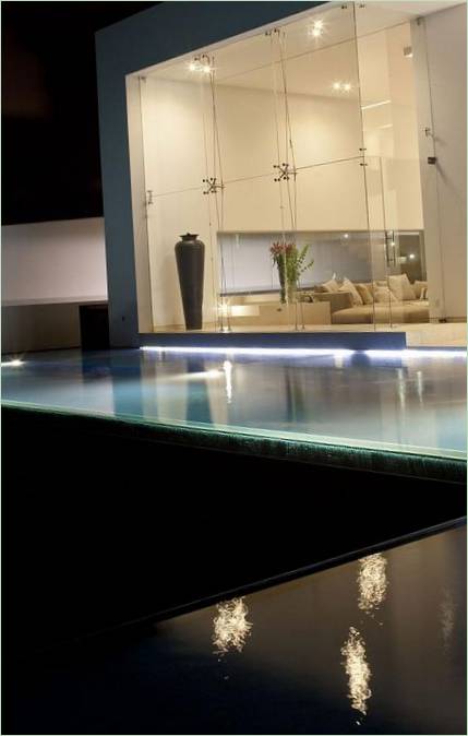 Piscina illuminata dalle pareti di vetro della villa