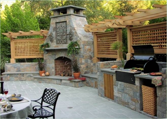 Forno e grill integrati nel piano di lavoro in pietra. Foto: idee per la decorazione della stanza
