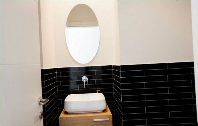 Piastrelle scure lucide nell'interno del bagno