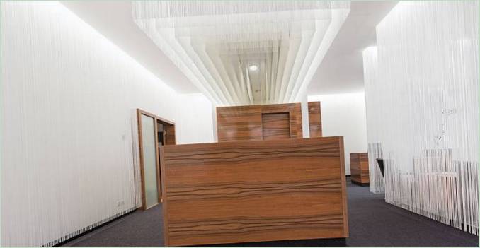 Lounge dell'aeroporto: un lampadario a cascata sopra il banco della reception in legno
