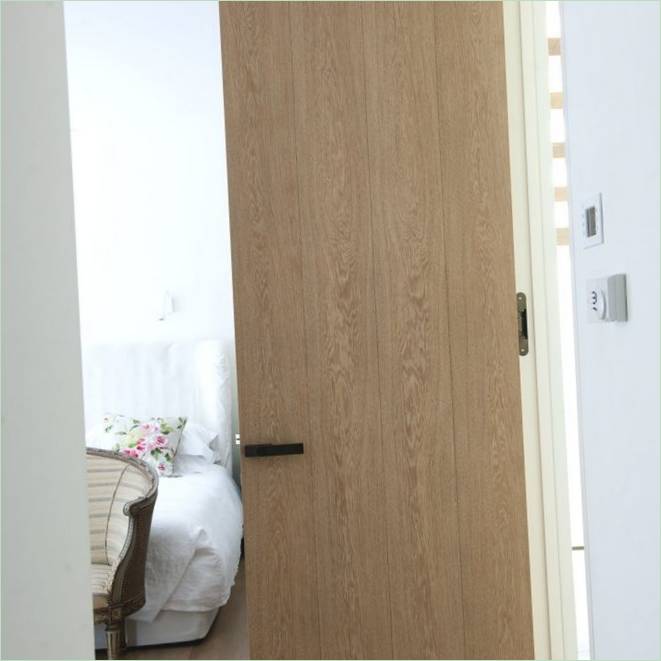 La luminosa porta della camera da letto in legno della Hyde Park House di Londra